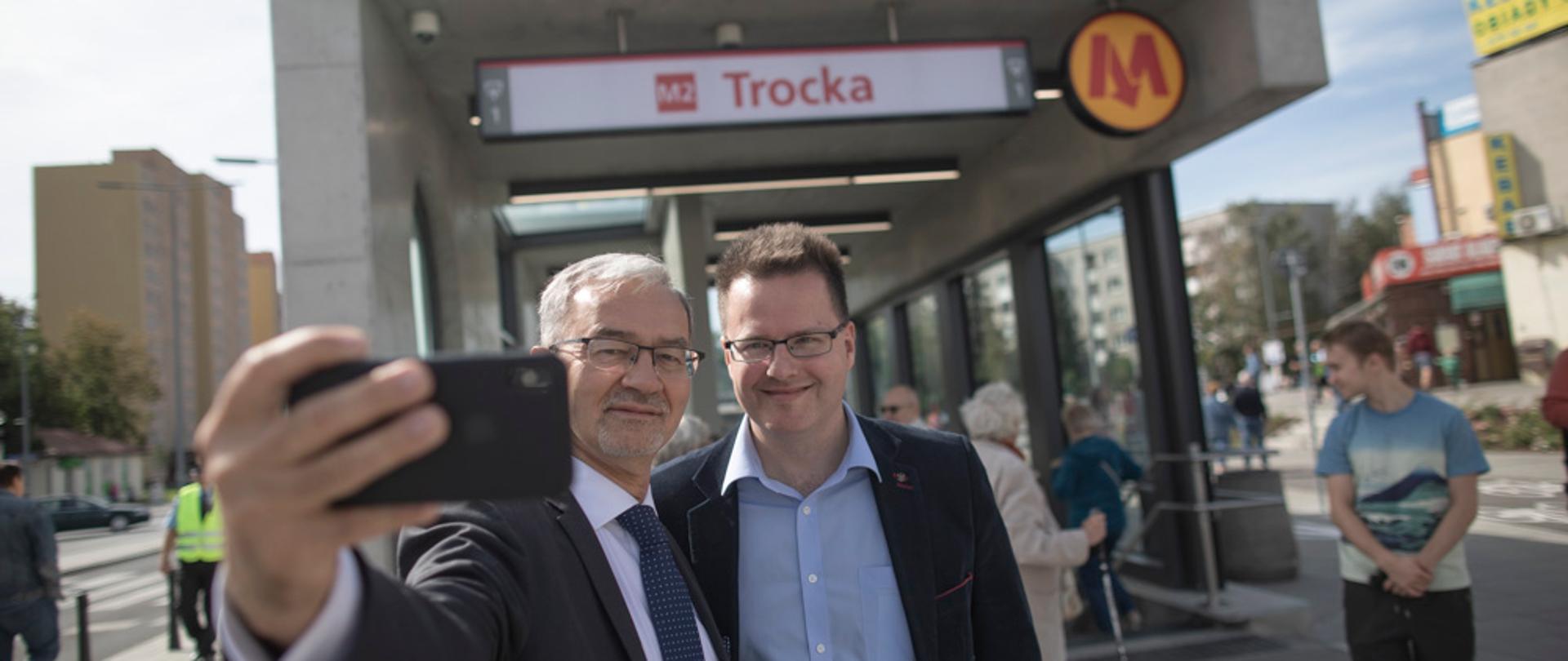 na tel przystanku metra Trocka minister Jerzy Kwieciński robi zdjęcie z wiceministrem infrastruktury Andrzejem Bittelem