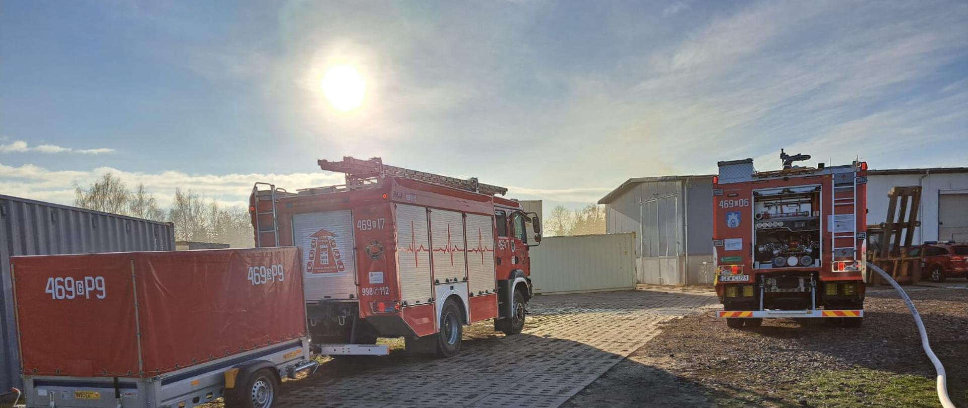 Samochody pożarnicze stoją na placu.