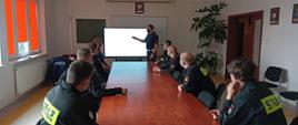 Zdjęcie przedstawia strażaków i policjantów słuchających wykładu