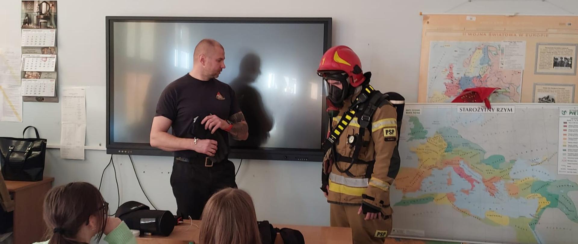 Strażak prezentujący umundurowanie specjalne oraz wyposażenie osobiste strażaka.