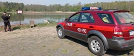 Kontrola terenów leśnych Nadleśnictwa Brzeg - zdjęcie przedstawia samochód operacyjny PSP w tle zbiornik wodny 