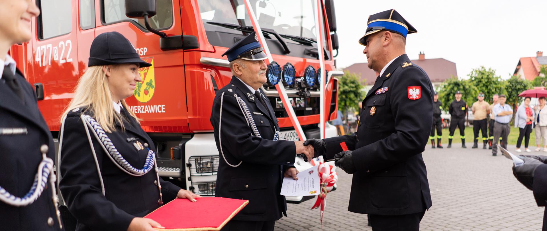 Na zdjęciu widzimy Zastępcę Komendanta Wojewódzkiego Państwowej Straży Pożarnej w Rzeszowie, który wręcza odznaczenia strażakom Ochotnikom. 