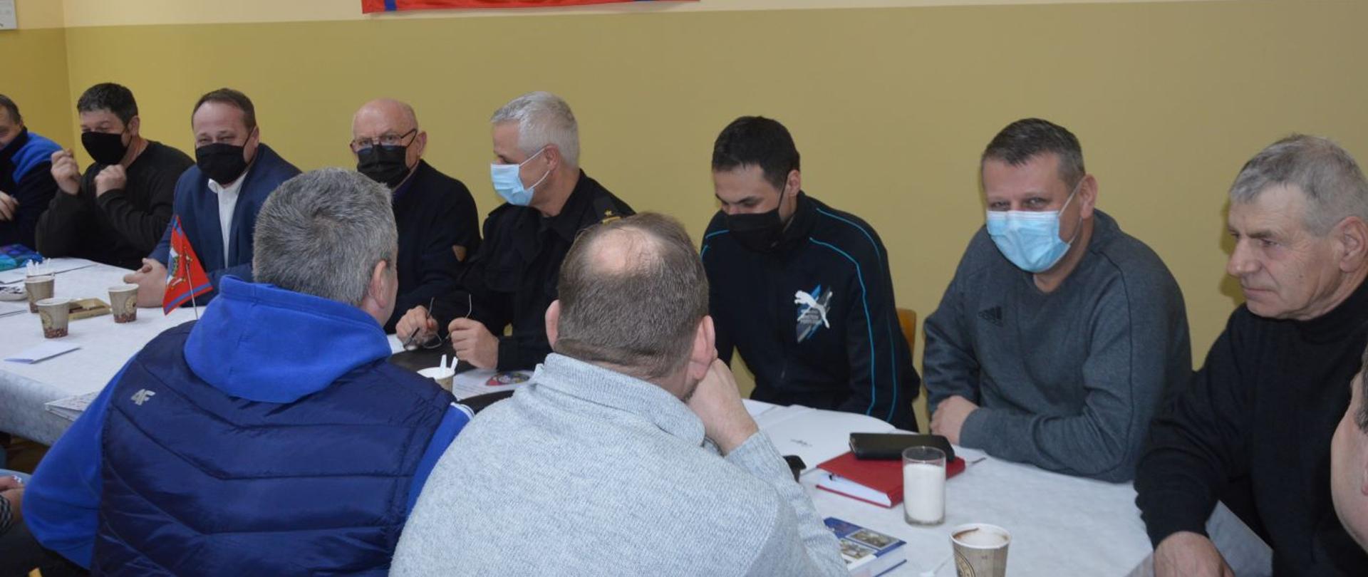 Posiedzenie prezydium ZOMG ZOSP RP w Jutrosinie. Sala w remizie OSP Szkaradowo. Przy stole siedzą uczestnicy spotkania, wśród nich jest ubrany w mundur dowódczo-sztabowy, zastępca komendanta powiatowego PSP w Rawiczu. Na ścianie zawieszona jest flaga ZOSP RP.