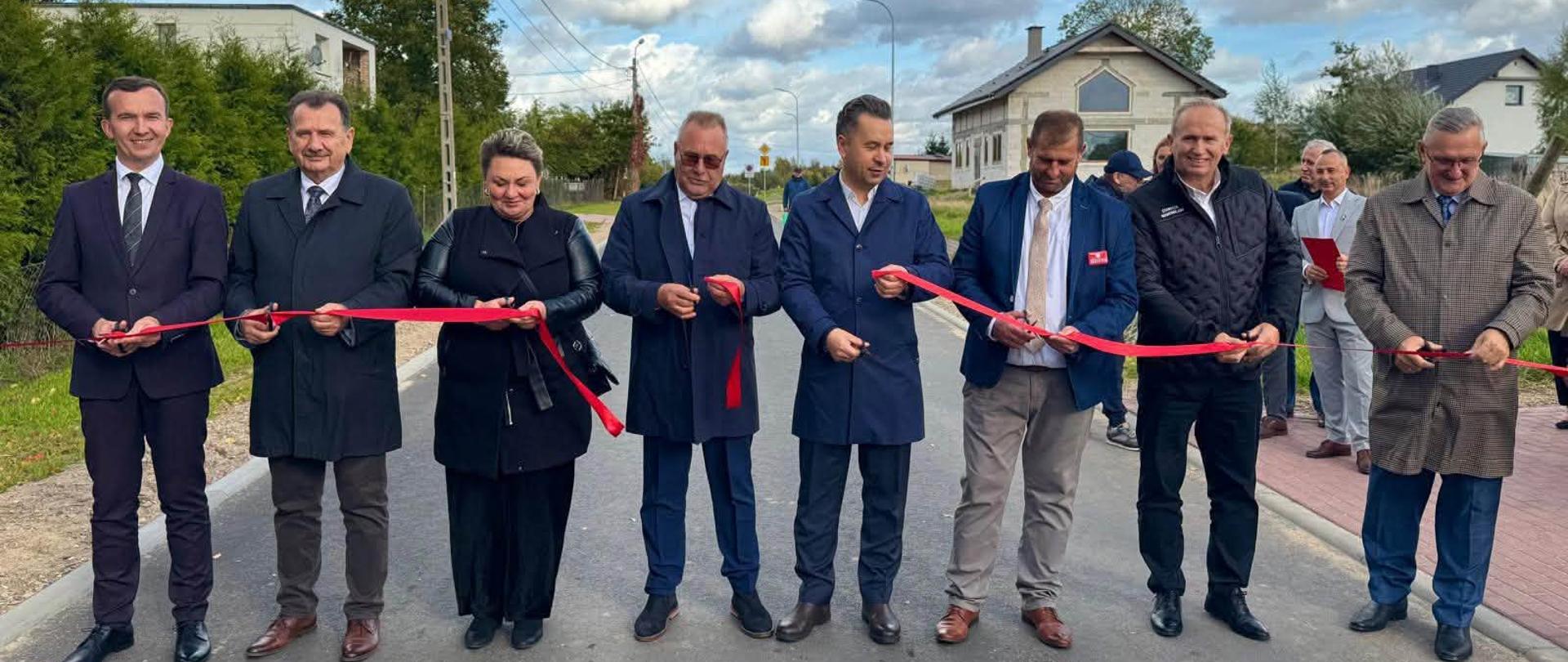 grupa oficjeli, w tym wicewojewoda, trzymają czerwoną wstążkę, którą przecinają