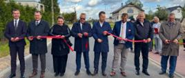 grupa oficjeli, w tym wicewojewoda, trzymają czerwoną wstążkę, którą przecinają