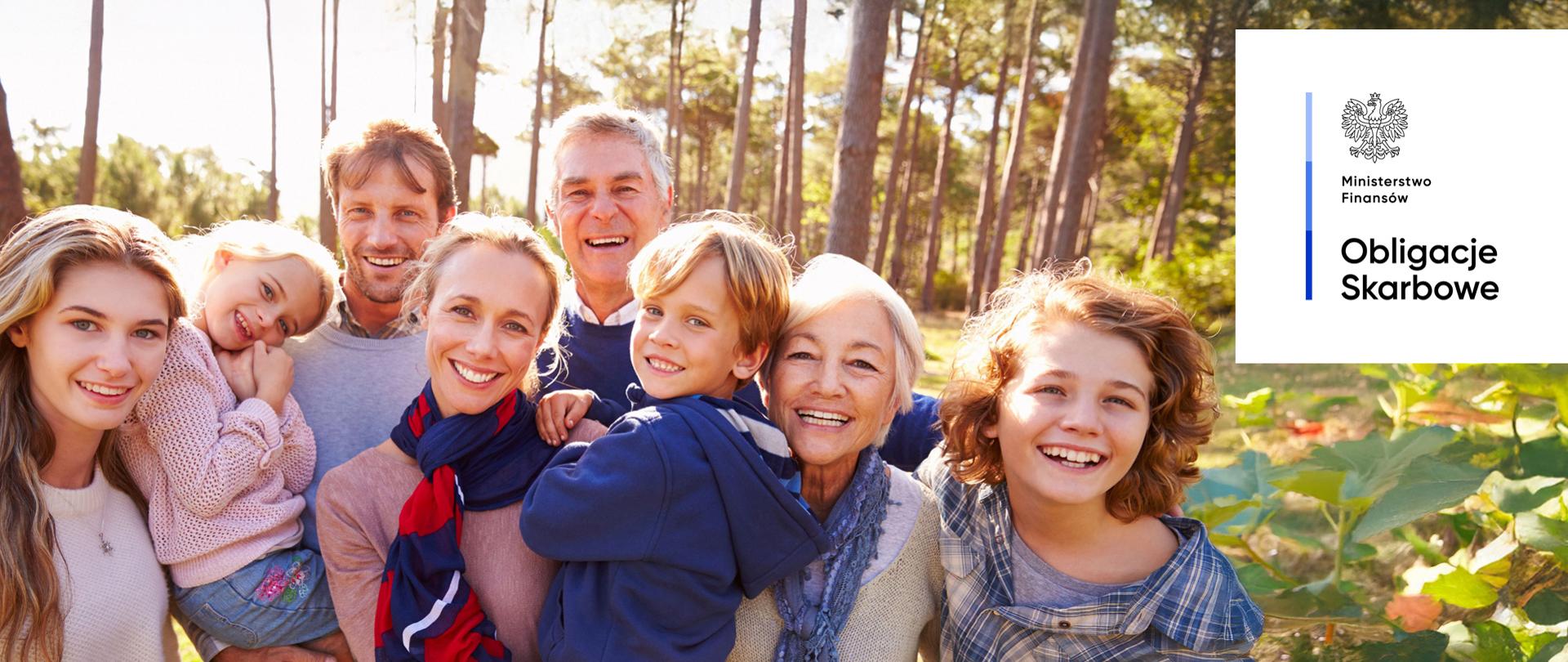 Uśmiechnięte osoby w różnym wieku, w lesie. Ministerstwo Finansów, Obligacje Skarbowe.
