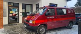 Na zdjęciu widać lekki samochód ratowniczy stojący prze budynkiem w którym, znajduje się punkt szczepień.
