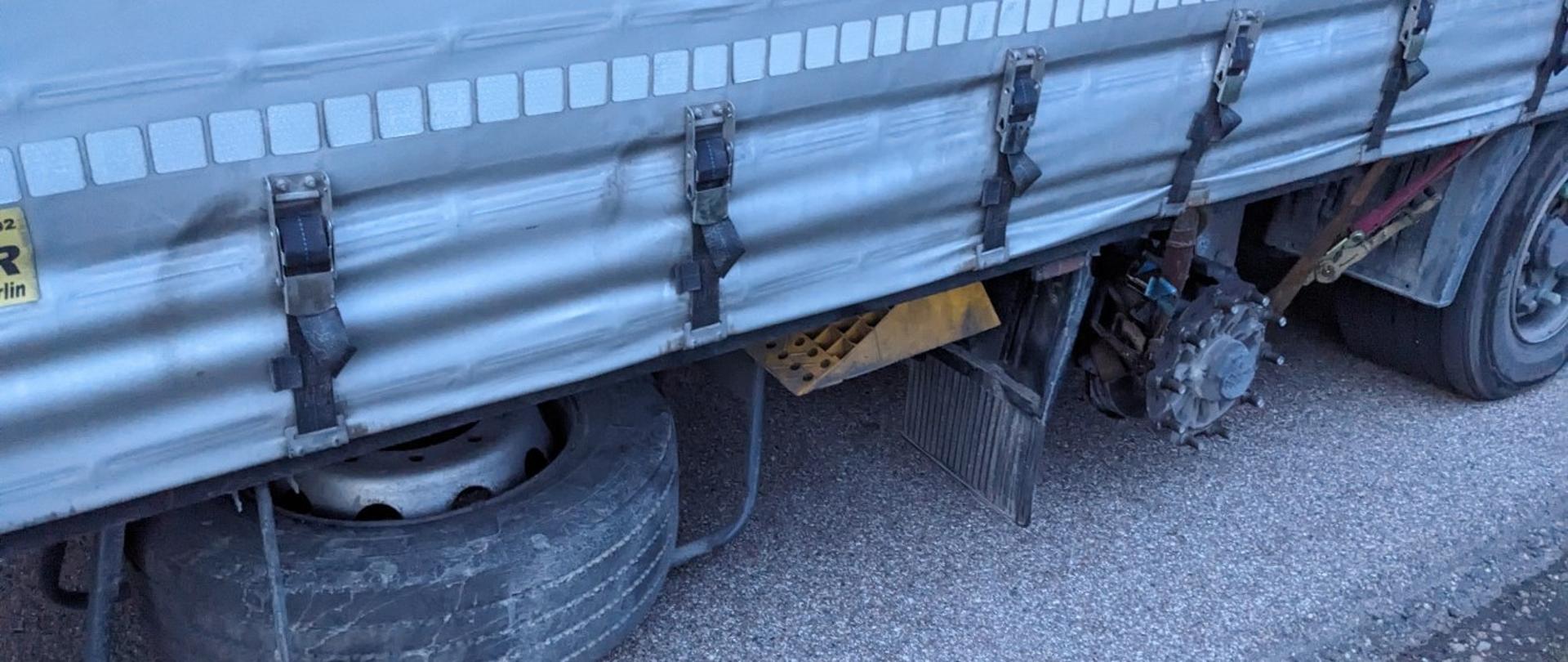 Naczepa ciężarowa ze zdemontowanym kołem na pierwszej osi. Niesprawny pojazd wycofali z ruchu inspektorzy podlaskiej Inspekcji Transportu Drogowego.