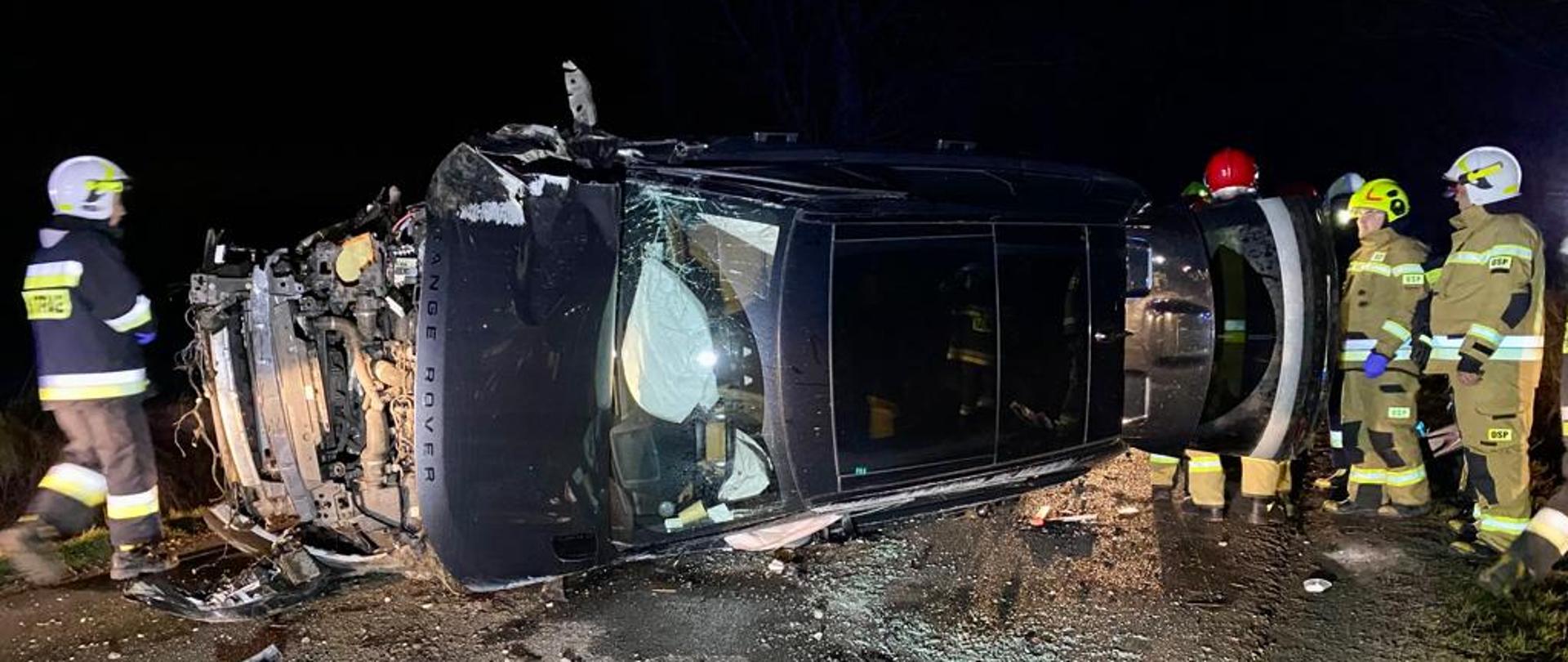 NOC, DROGA, STRAŻACY, SAMOCHÓD LEŻY NA BOKU