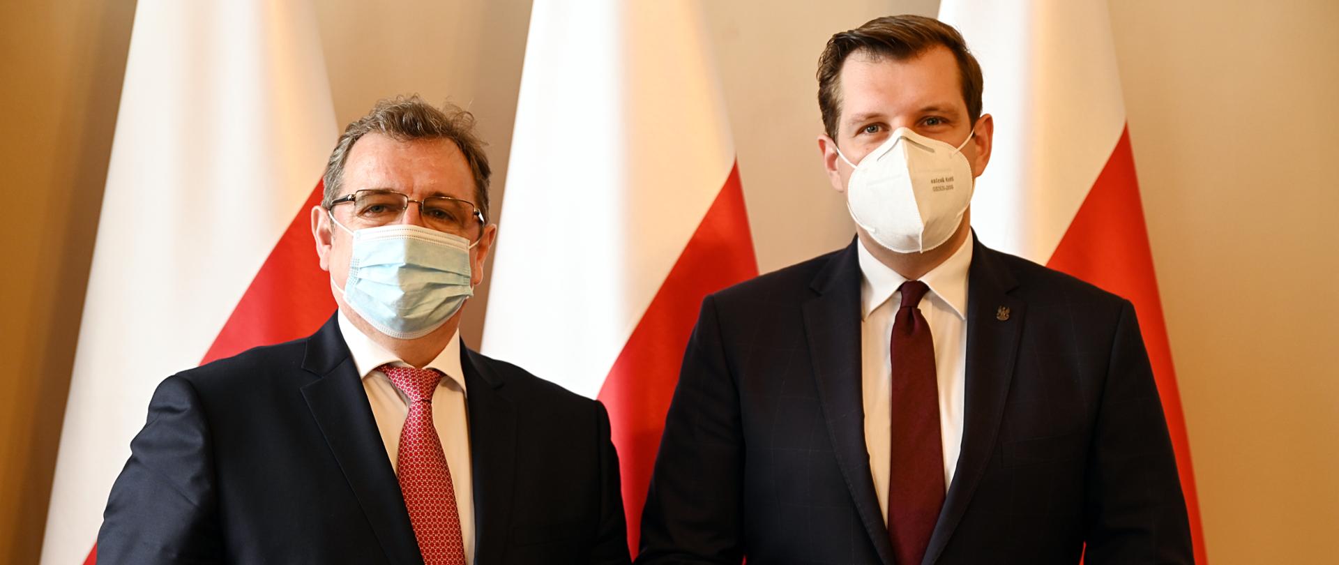 Wojewoda łódzki Tobiasz Bocheński stoi wraz z ambasadorem Republiki Mołdawii JE Igor Bodiu za nimi w tle flagi w kolorze biało-czerwonym, obaj pozują do zdjęcia