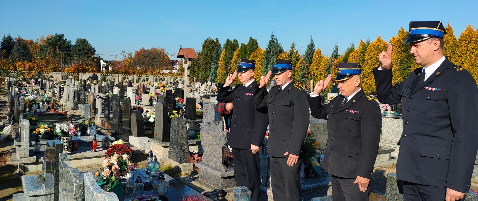 Funkcjonariusze Komendy Miejskiej Państwowej Straży Pożarnej w Zabrzu salutują przy grobie strażaka