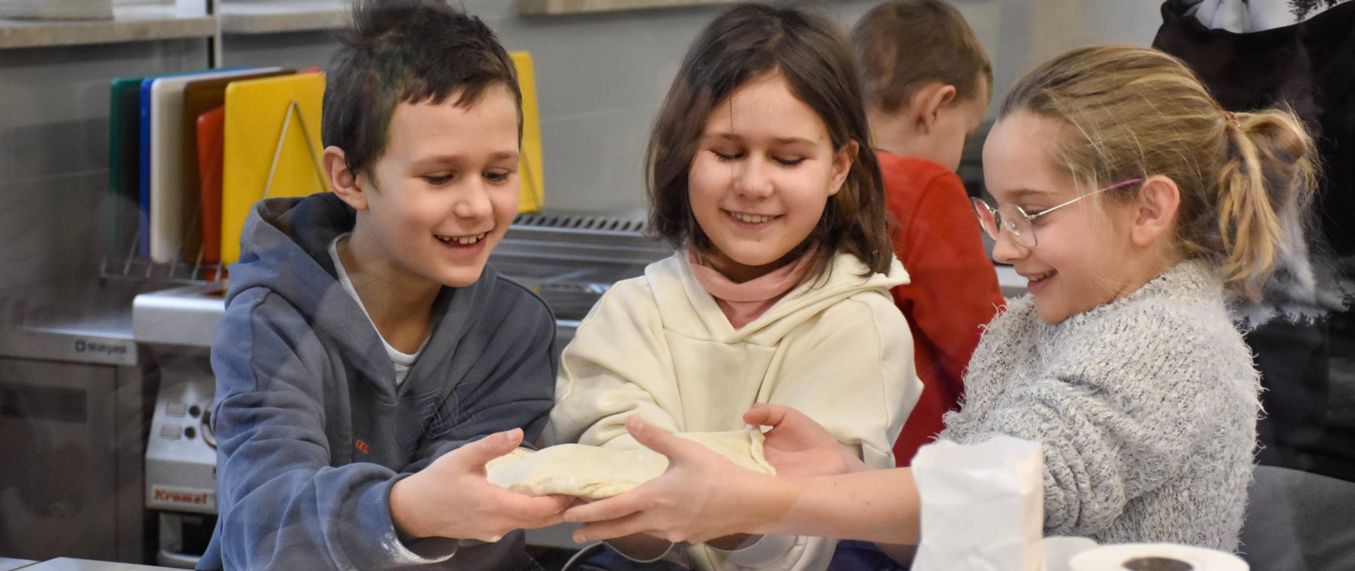 Grupka dzieci podczas przygotowywania pizzy 