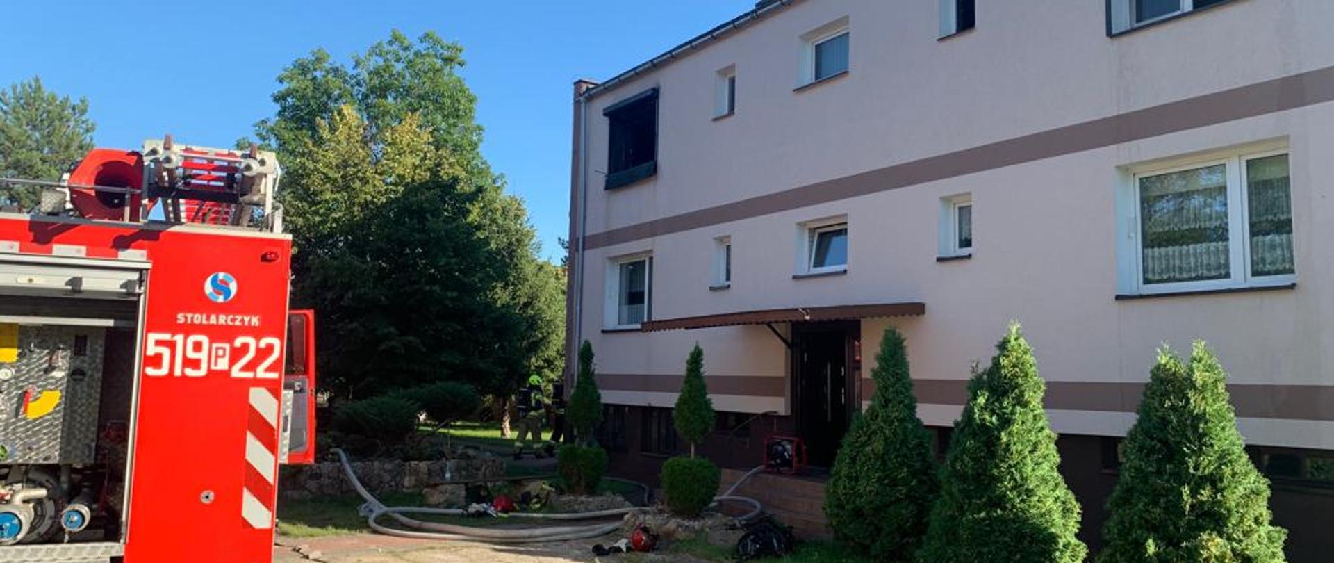 Wóz bojowy i rozwinięta linia gaśnicza do budynku