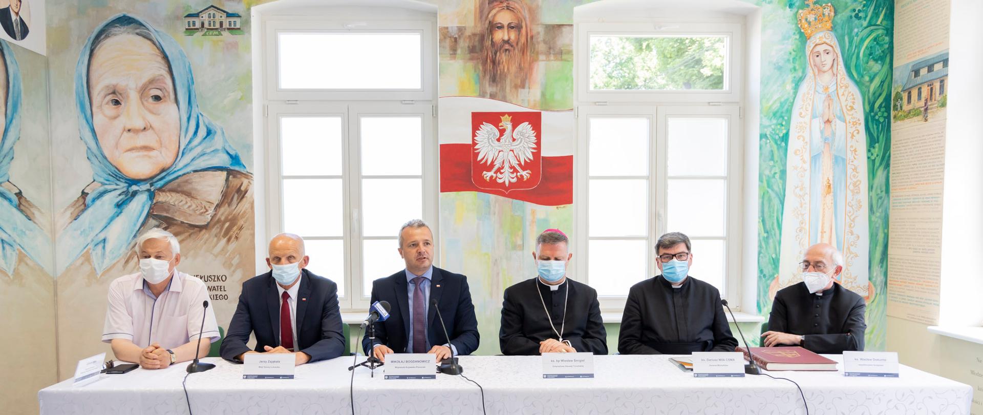 sześciu mężczyzn siedzących za stołem, konferencja prasowa 