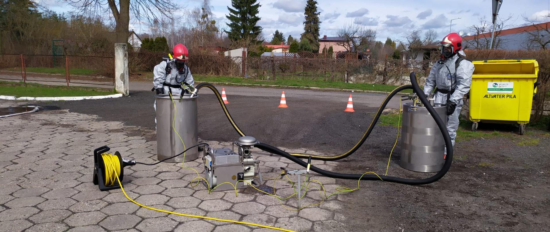 Na zdjęciu widnieją strażacy w trakcie ćwiczeń z zakresu ratownictwa chemicznego. 