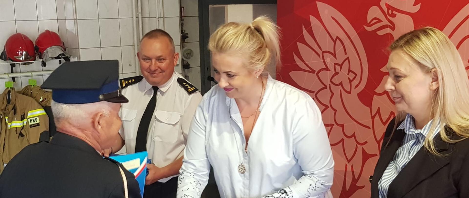 Widoczni uczestnicy podczas wręczenia decyzji przyznających świadczenie ratownicze.