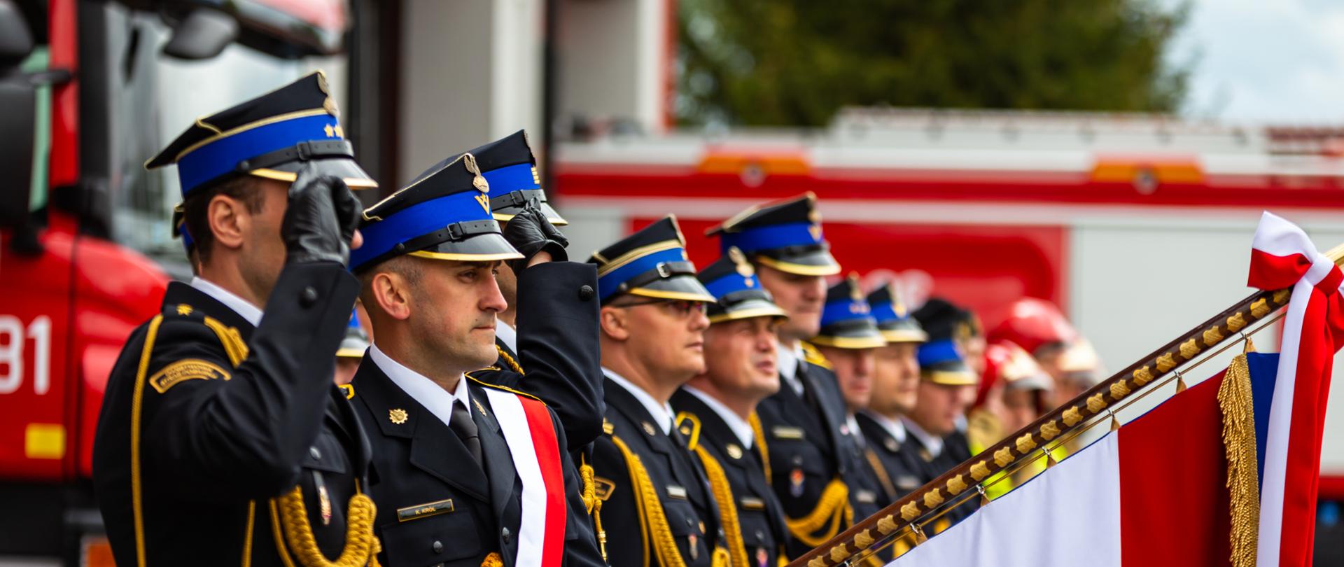 Pododdział strażaków podczas oddawania honoru przez sztandar jednostki 