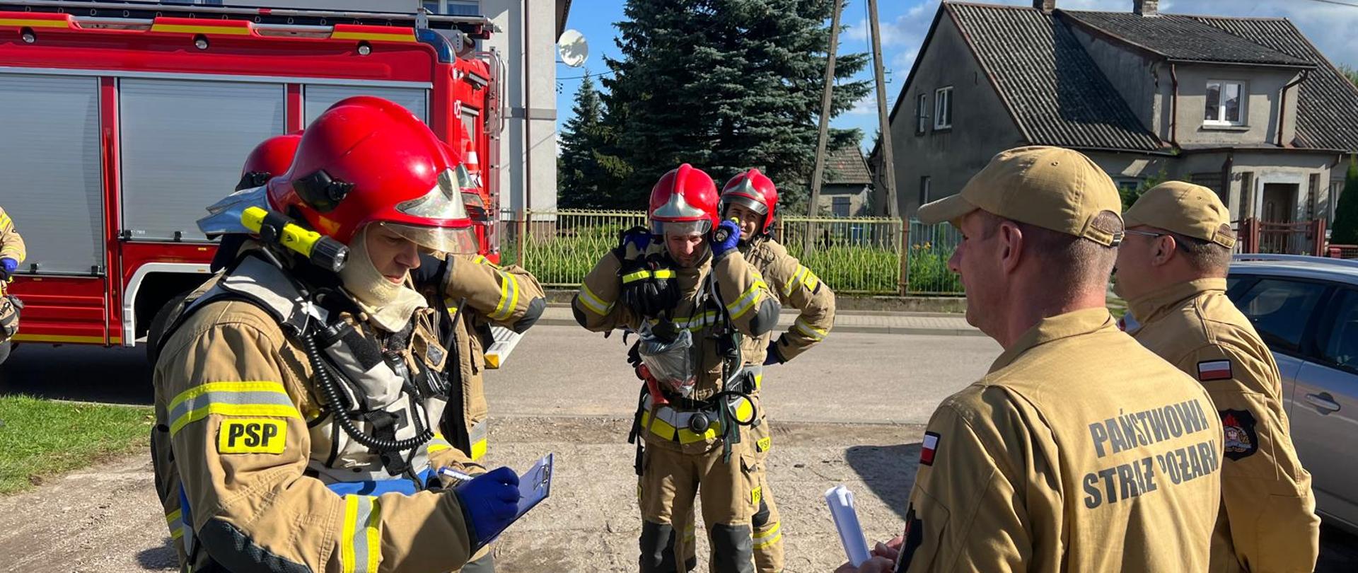 Strażacy stoją i omawiają ćwiczenia