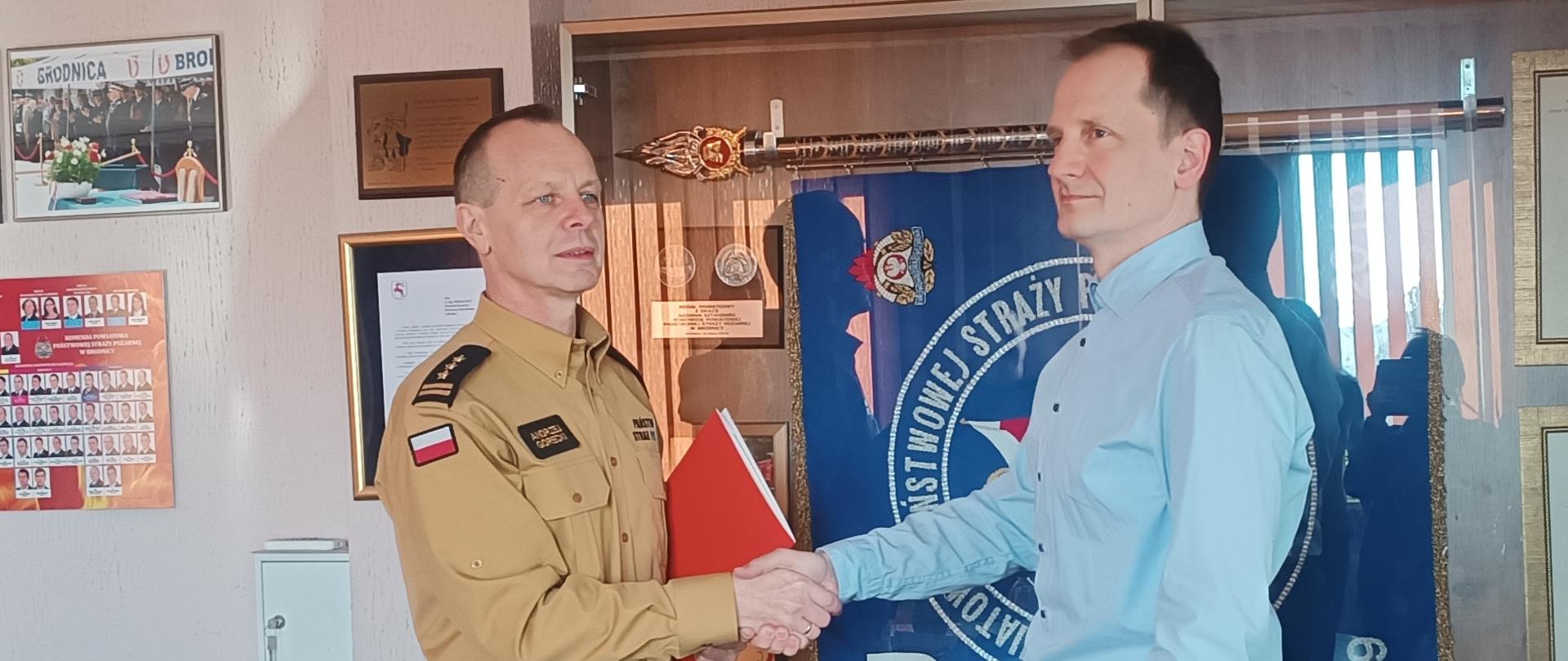 Zdjęcie przedstawia Komendanta Powiatowego PSP w Brodnicy st. bryg. Andrzeja Góreckiego wręczającego nagrodę obchodzącemu jubileusz 20-lecia pracy mgr inż. Marcinowi Jabłońskiemu.