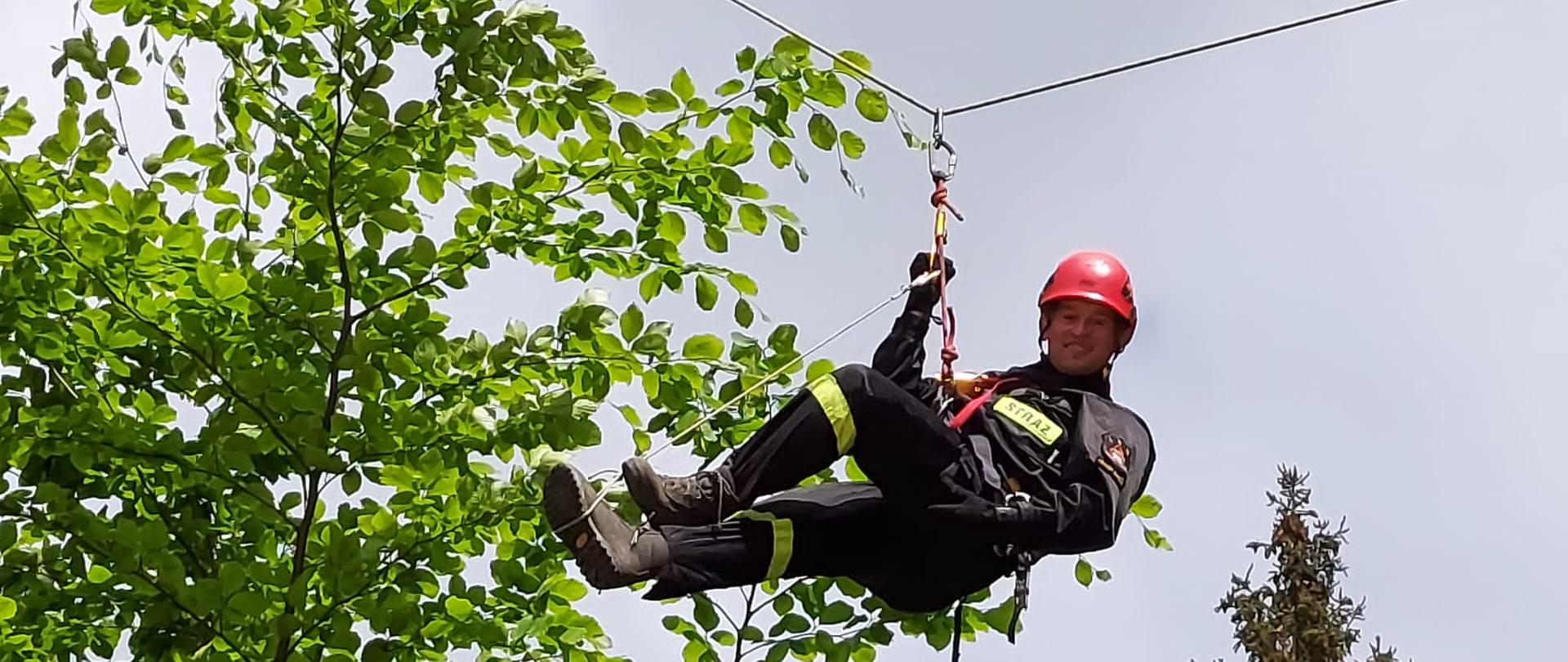 ratownik na linie pomiędzy drzewami