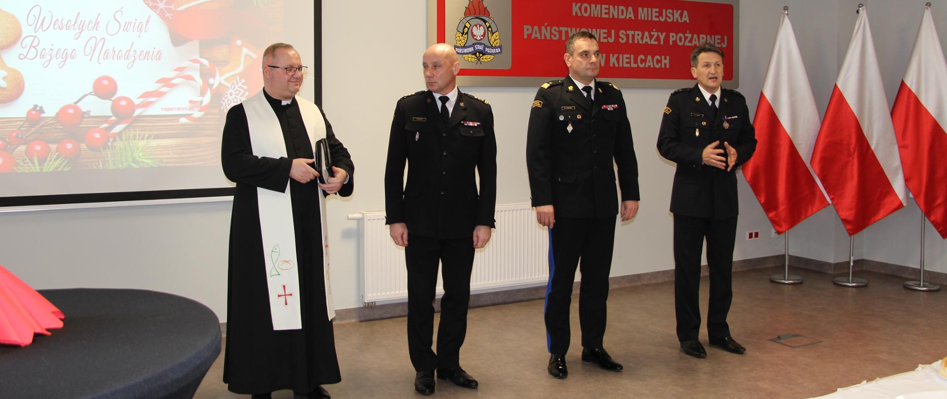 Zdjęcie przedstawia zaproszonych na uroczyste spotkanie opłatkowe gości którym towarzyszy gospodarz: komendant miejski PSP w Kielcach.