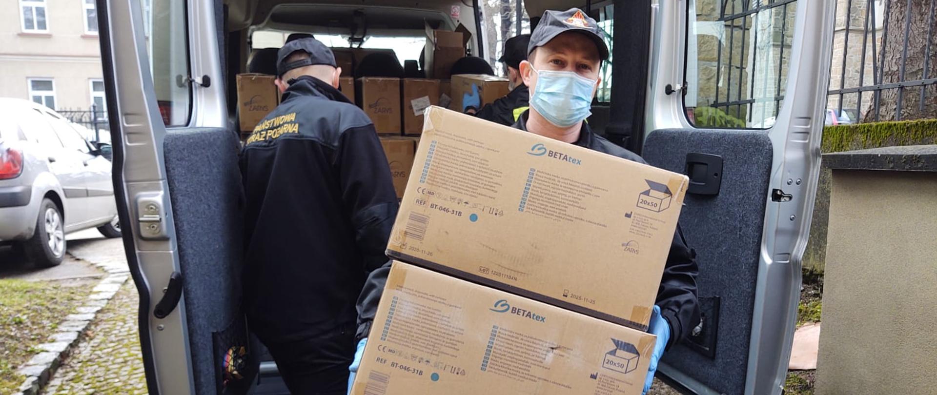 Na zdjęciu strażacy z JRG KP PSP w Jaśle podczas rozładunku maseczek oraz płynów dezynfekcyjnych przy kościele Fara w Jaśle.