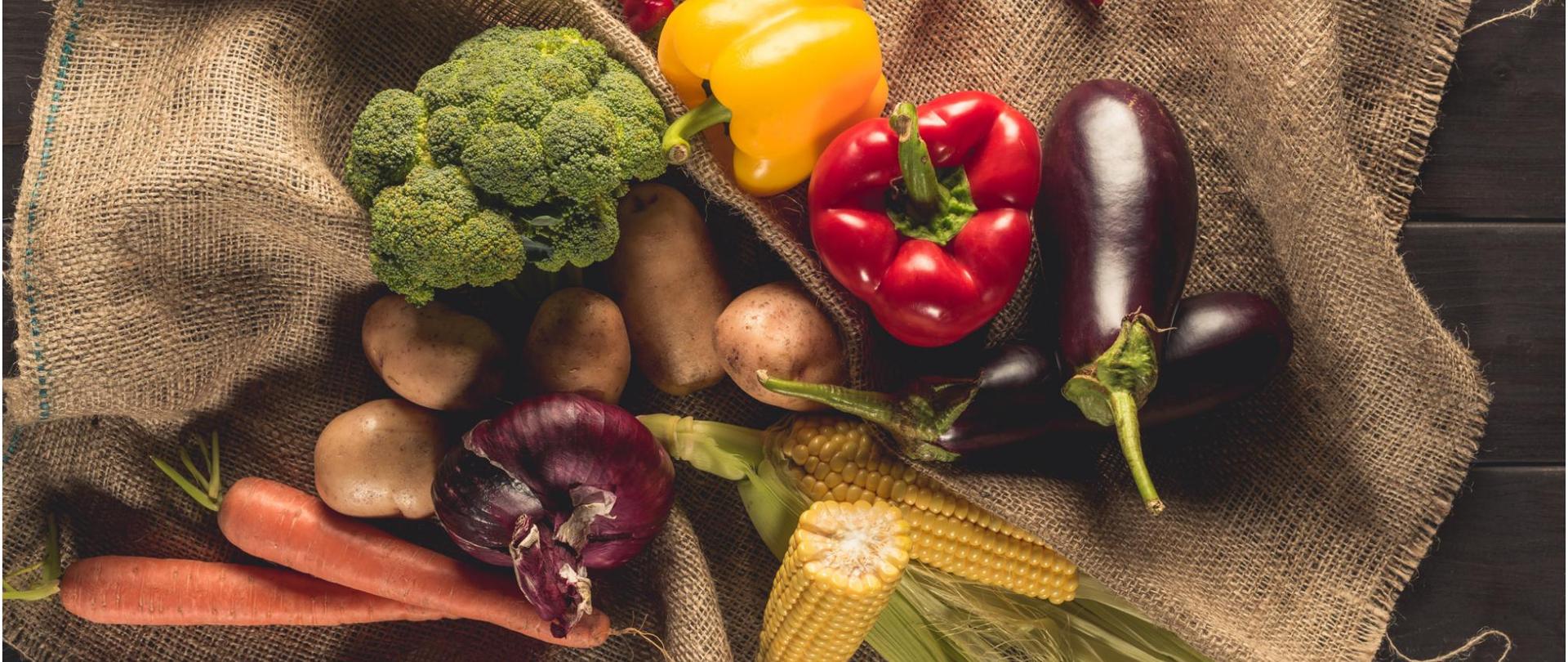 Na zdjęciu są warzywa leżące na jutowym worku.