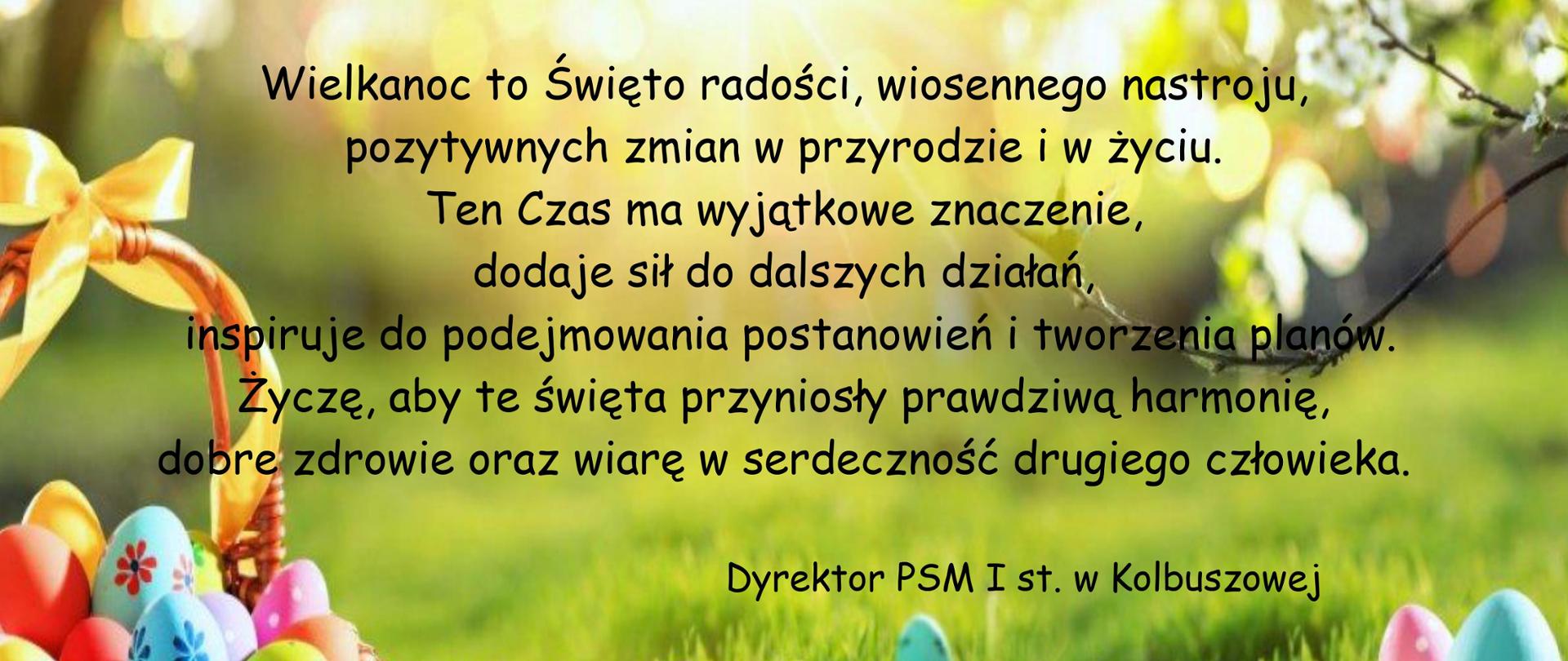 Plakat na zielonym tle imitującym trawę z kolorowymi pisankami w koszyczku oraz w trawie. Życzenia Wielkanocne są w kolorze czarnym na całej powierzchni plakatu.