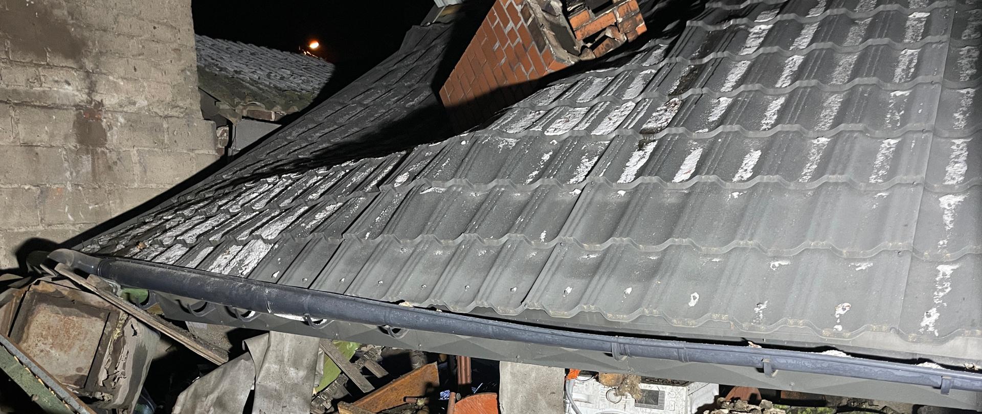zdjęcie przedstawia kawałek dachu kryty blachą oraz gruzowiska po wybuchu pieca