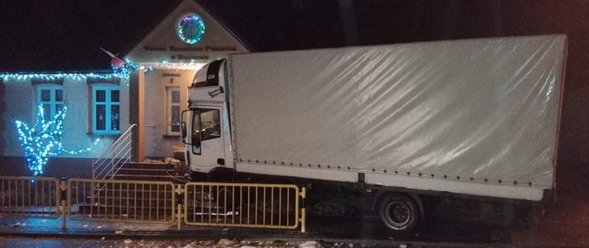 Po prawej stornie zdjęcia znajduje się samochód ciężarowy , który wypadł z drogi i uderzył w budynek Gminnej Biblioteki Publicznej w Dalikowie 