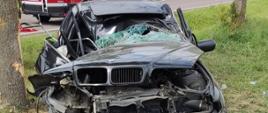 Wypadek w m. Zygmuntowo. Rozbity, czarny samochód osobowy marki BMW.