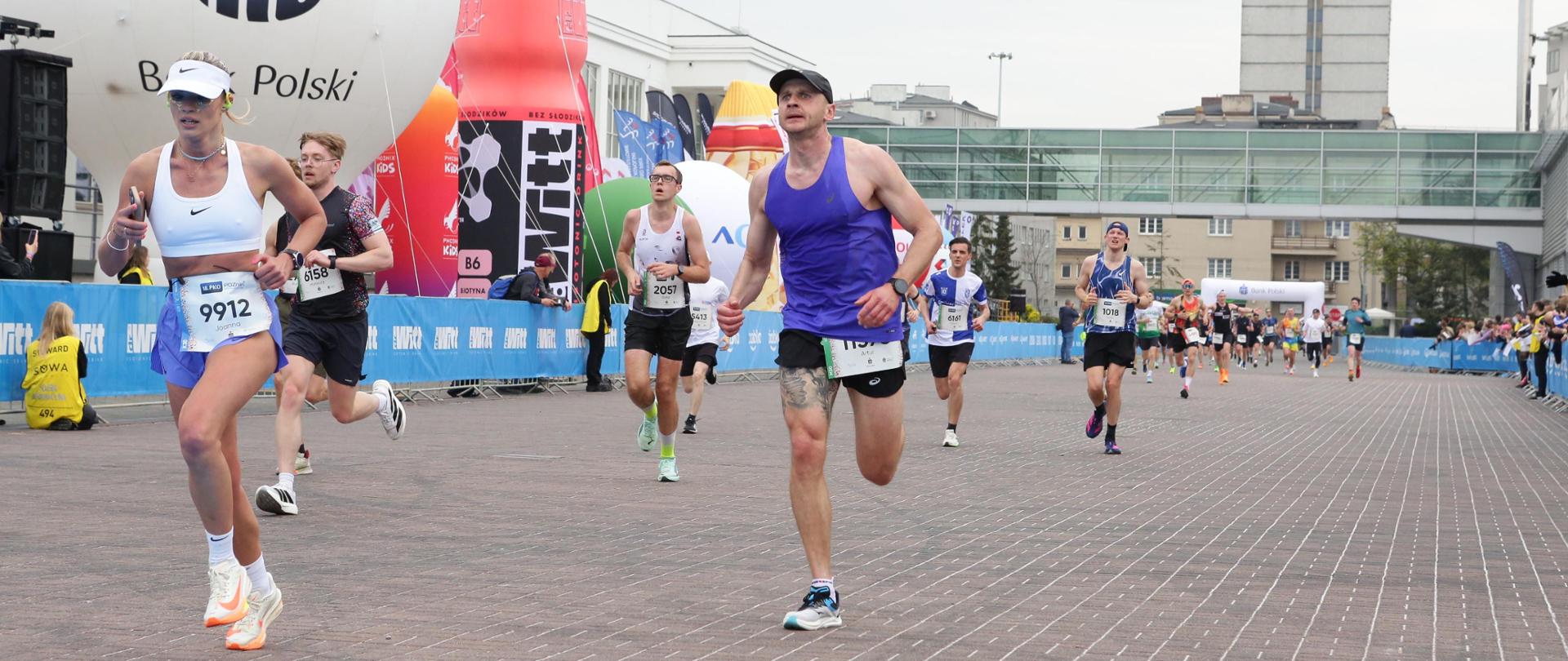 Na zdjęciu młodszy ogniomistrz Artur Hass podczas biegu na trasie półmaratonu 18. PKO Poznań Półmaratonu. W tle inni uczestnicy.