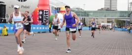 Młodszy ogniomistrz Artur Hass podczas biegu na trasie półmaratonu 18. PKO Poznań Półmaratonu. W tle inni uczestnicy.