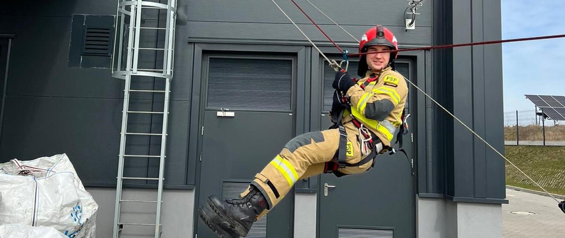 Strażak zjeżdżający na linie z budynku