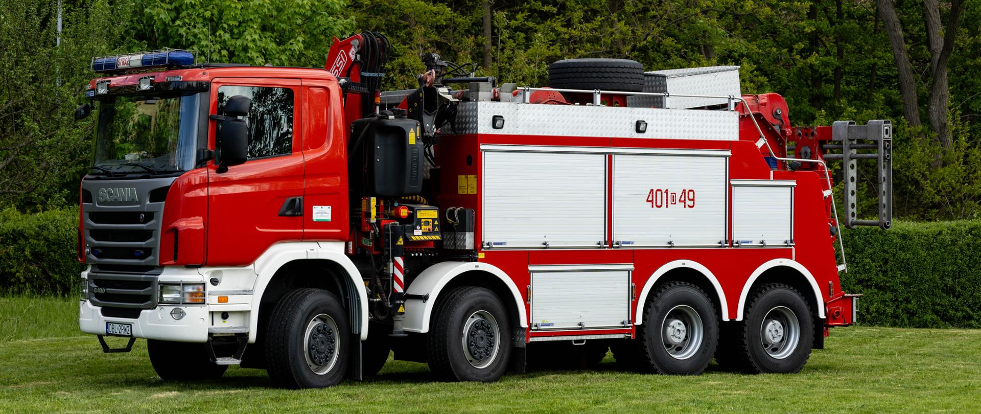 Ciężki, czteroosiowy samochód ratownictwa technicznego Scania G480 typu Mega-City. Czerwone nadwozie z numerem „401[D]49” wyposażone jest w hydrauliczny dźwig żurawiowy za kabiną oraz specjalistyczny widłowy holownik z tyłu pojazdu.
