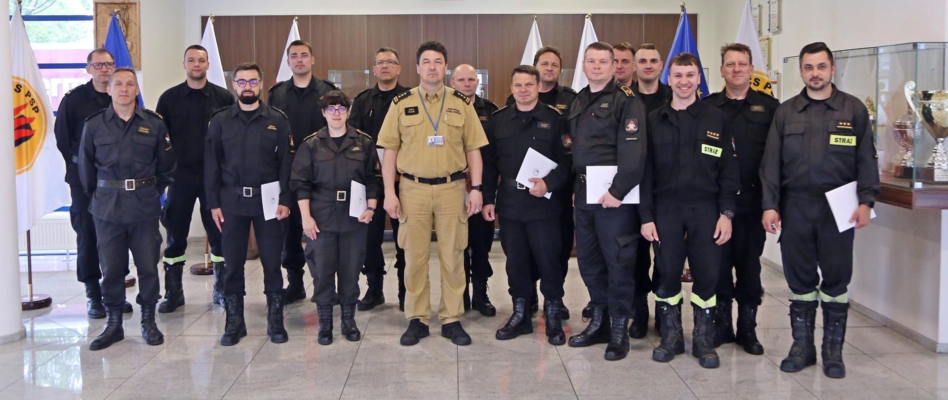 Grupowe zdjęcie uczestników warsztatów (16 funkcjonariuszy PSP) w towarzystwie Komendanta Centralnej Szkoły PSP