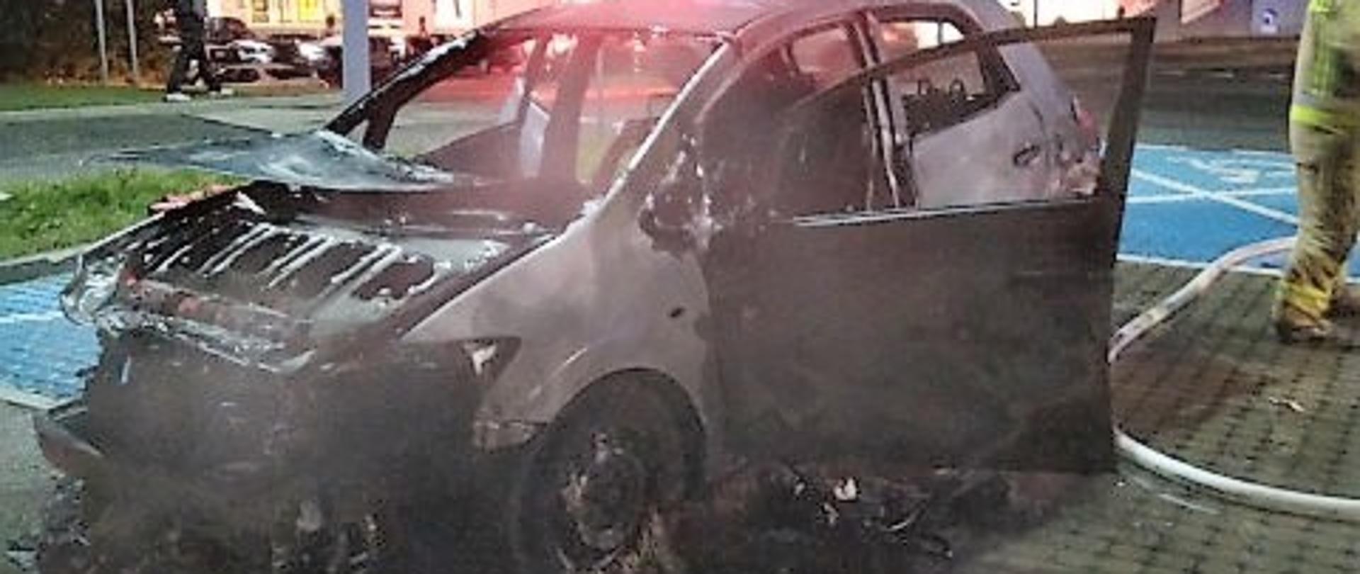 Zdjęcie przedstawia zniszczony przez ogień samochód osobowy. 