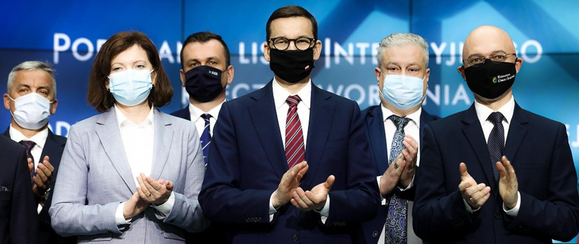 Premier stoi wśród ludzi.