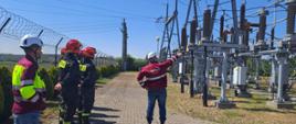 Szkolenie w zakresie zagrożeń ze strony urządzeń elektroenergetycznych. Zdjęcie przedstawia strażaków PSP oraz pracowników firmy Energa podczas szkolenia.
