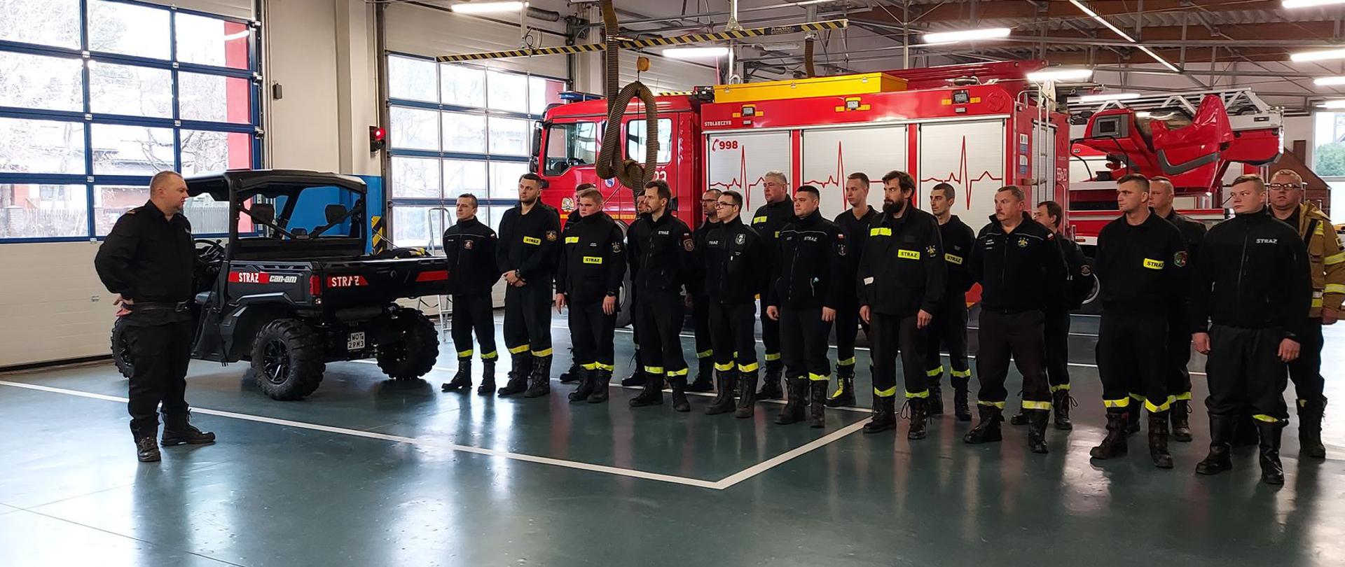 Na zdjęciu druhowie OSP, podczas podsumowania szkolenia. Zbiórka odbywa się na garażu komendy powiatowej.