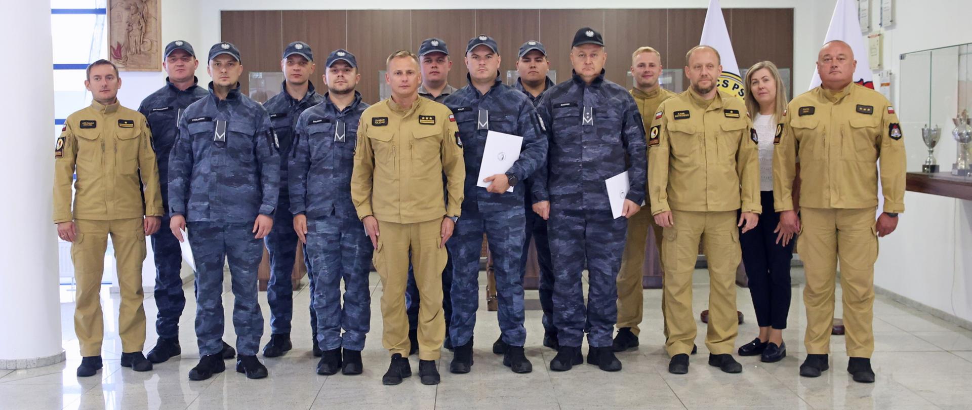 Pamiątkowe zdjęcie grupowe funkcjonariuszy Straży Marszałkowskiej (8 osób) w towarzystwie Zastępcy Komendanta Centralnej Szkoły PSP, kobiety oraz czterech funkcjonariuszy CS PSP