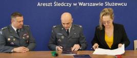 Od prawej strony siedzą za stołem i podpisują umowę: Dyrektor Generalna Głównego Inspektoratu Transportu Drogowego Małgorzata Intze i dwaj przedstawiciele Służby Więziennej.