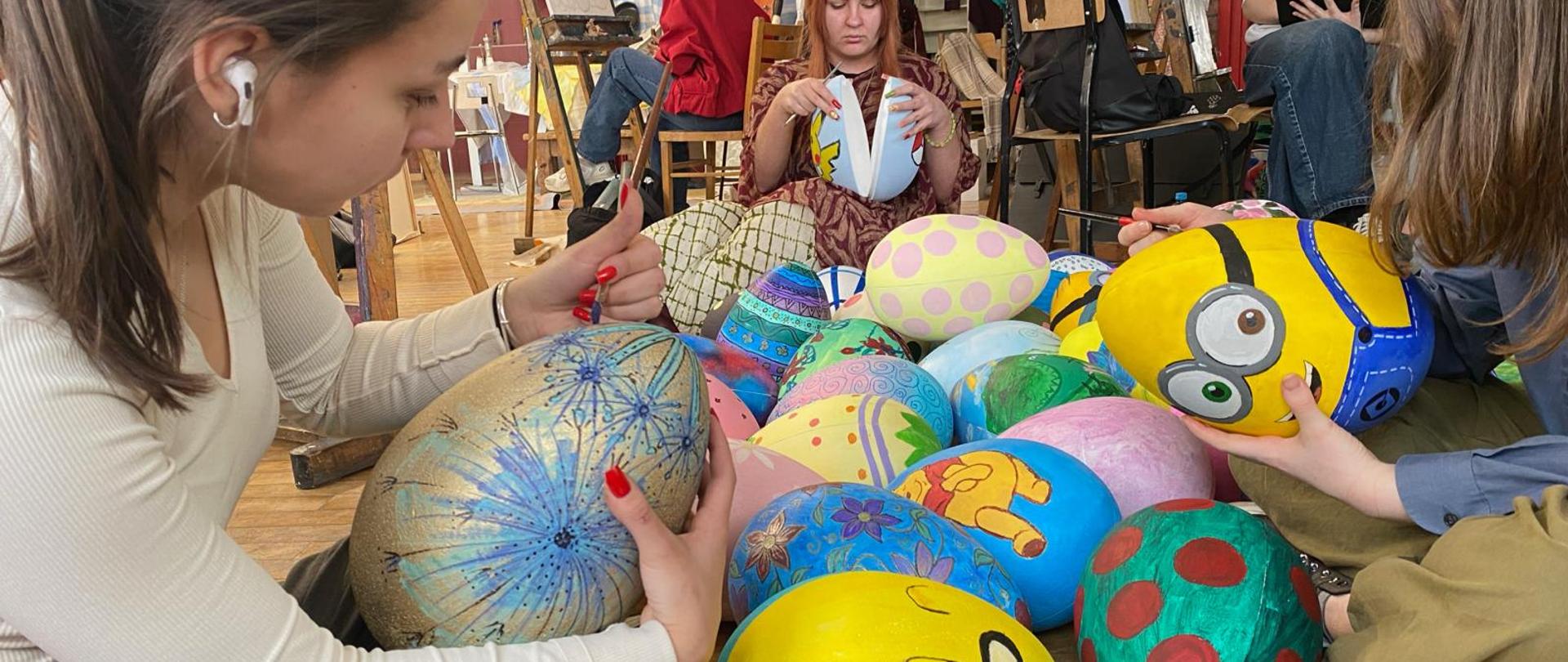 Fotografia ukazująca osoby malujące jaja