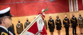 Sztandar Morskiego Oddziału Straży Granicznej, obok stoją funkcjonariusze jednostki.