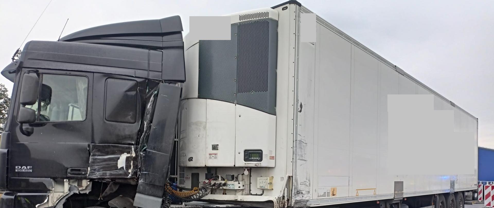 Widać uszkodzony samochód ciężarowy od strony kierowcy na pasie ruchu