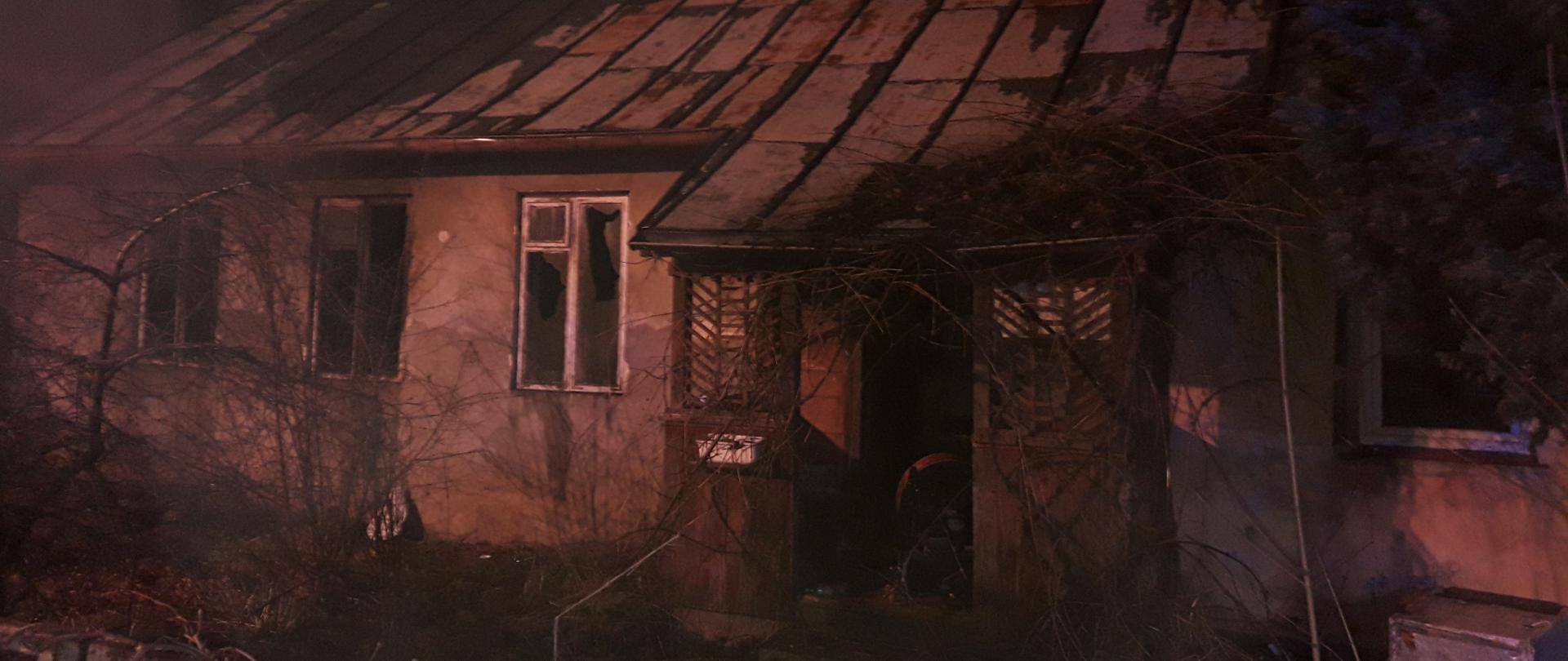 Widok dymiącego pustostanu nocą.