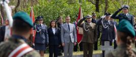 Wojewoda Kujawsko-Pomorski Michał Sztybel, Naczelnik Delegatury Instytutu Pamięci Narodowej w Bydgoszczy Edyta Cisewska podczas uroczystości na Cmentarzu Wojennym w Smukale. Towarzyszą im salutujący przedstawiciele służb mundurowych. Na pierwszym planie, odwróceni tyłem, żołnierze z kompanii honorowej. 
