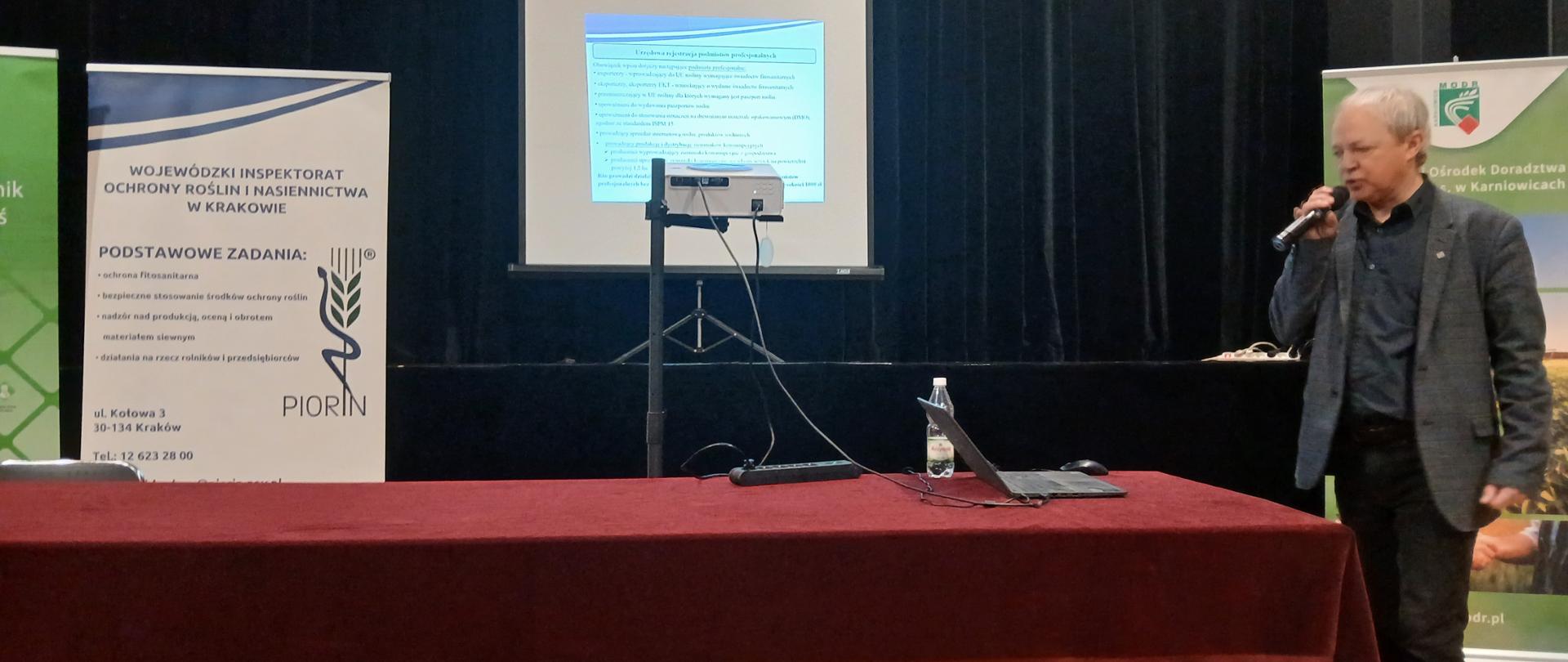 Widok sali szkoleniowej i mężczyzny omawiającego prezentację