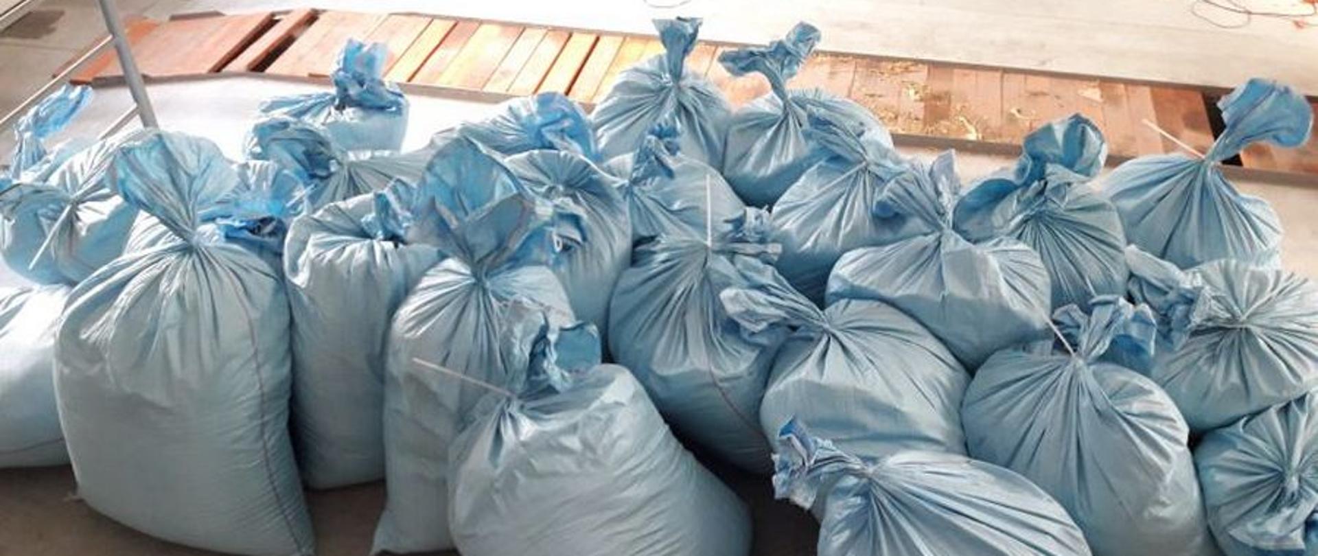 Worki z tytoniem ułożone na podłodze.