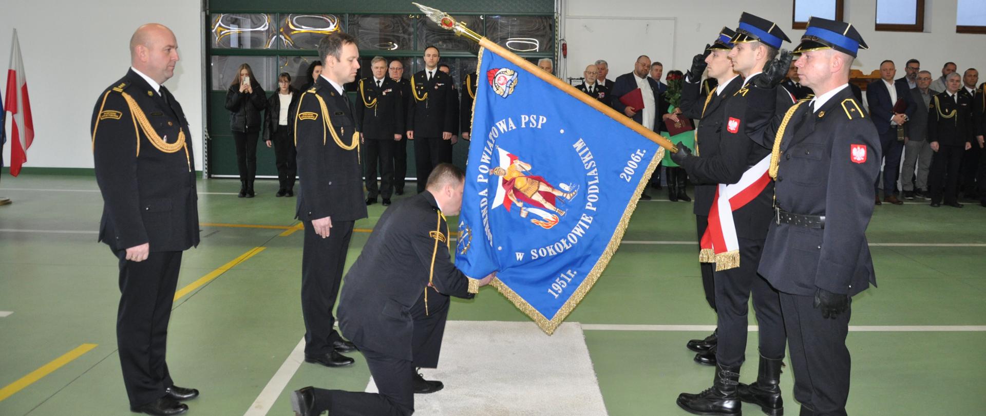 strażacy w mundurach i ludzie cywilni stoją na tle ściany - pamiątkowe zdjęcie. 